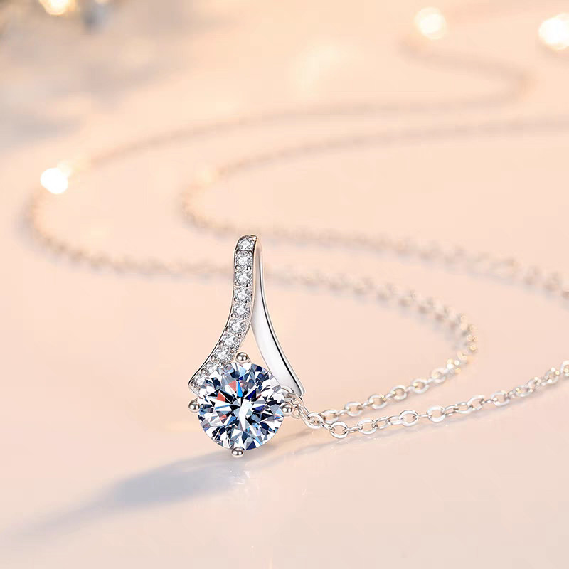 Round Cut Solitaire Diamond White Gold Necklace With Elongated Split Pave Bar Bail on table