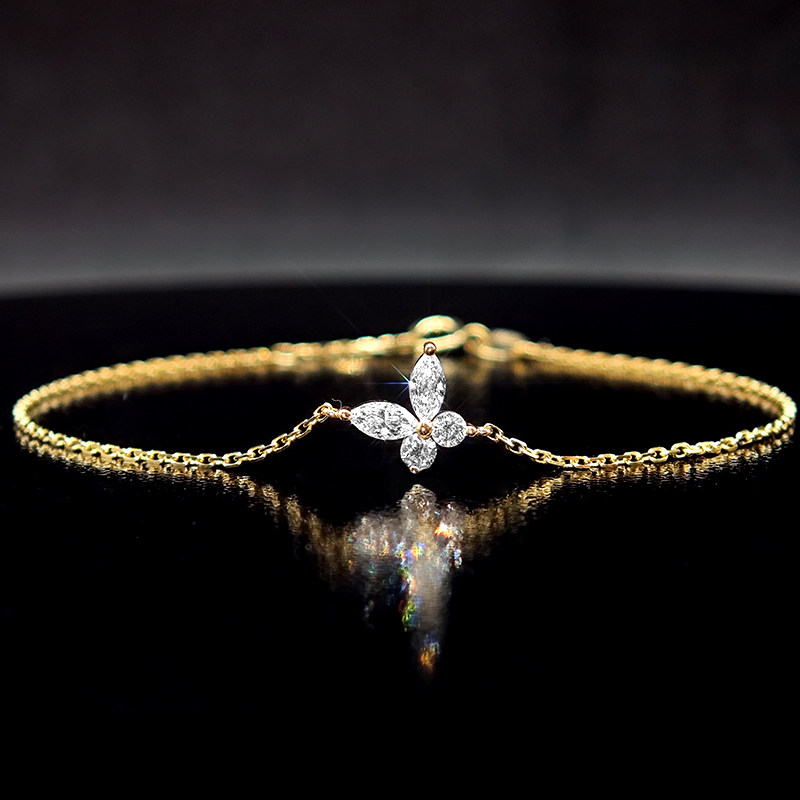5 Prong Diagonal Butterfly Design Ethical Lab Diamond Yellow Gold Bracelet lay on desk