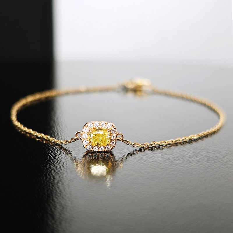 Solitaire Cushion Halo Yellow Lab Diamond Bracelet in Yellow Gold on desk
