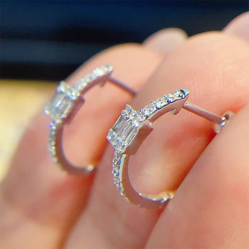 White Gold Baguette Stone & Half Pave Synthetic Diamond Huggie Earring in hand