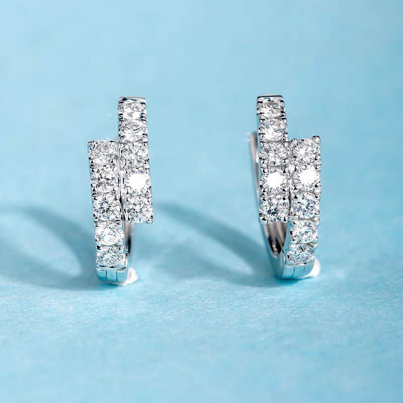 Symmetrical Bypass Overlapping Half Pave Lab Grown Diamond Huggie Earrings in blue background