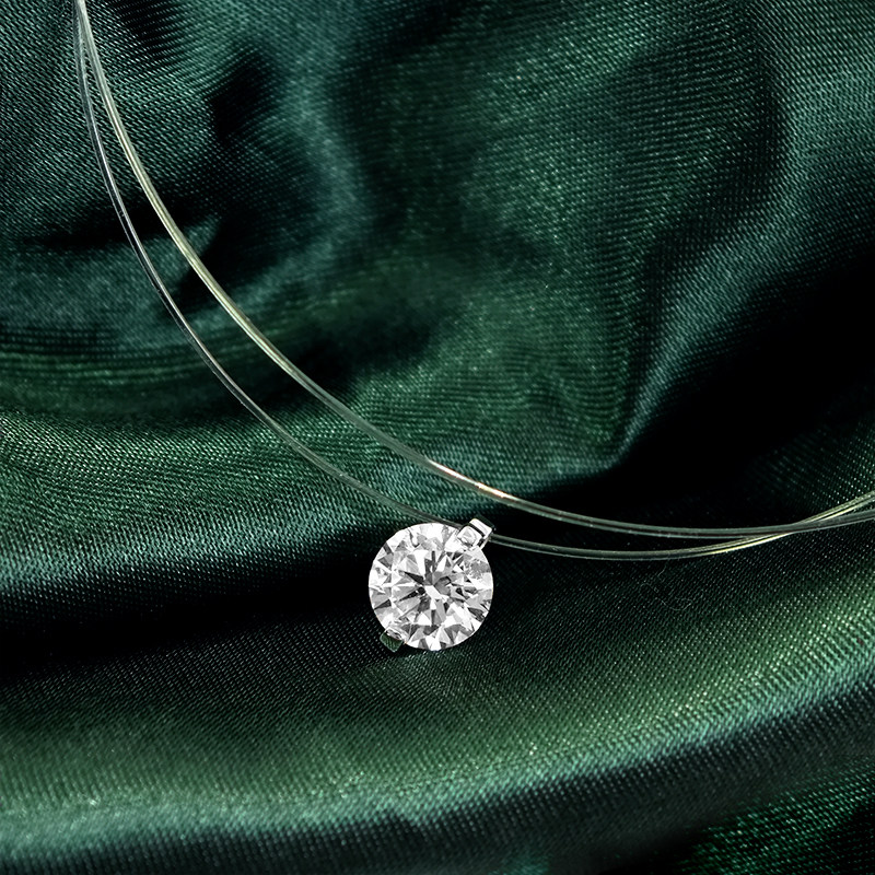 2 Prong Solitaire Pierced Round Cut Floating Set Diamond Necklace With Transparent Plastic Rope on green cloth