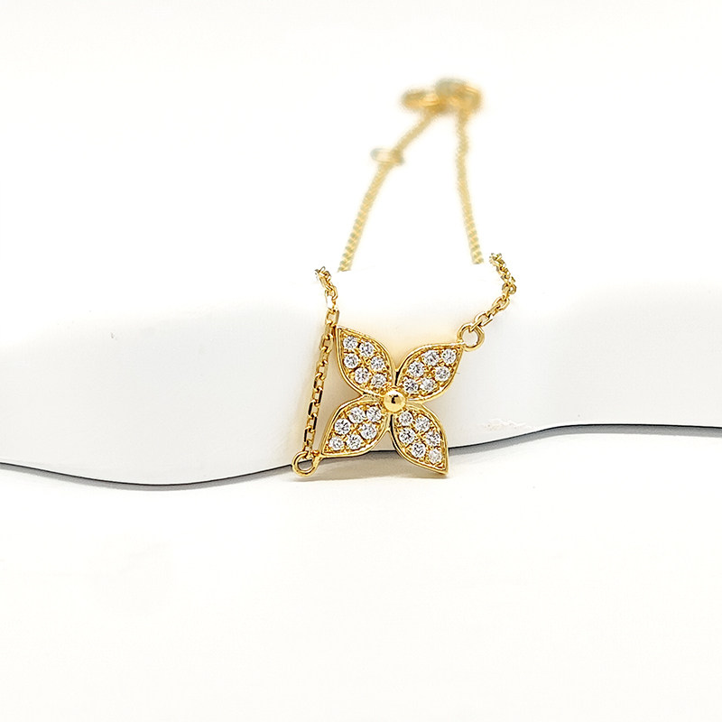 Yellow Gold Pave Set 4-Petal Star Lab Grown Diamond Dainty Bracelet lay on table