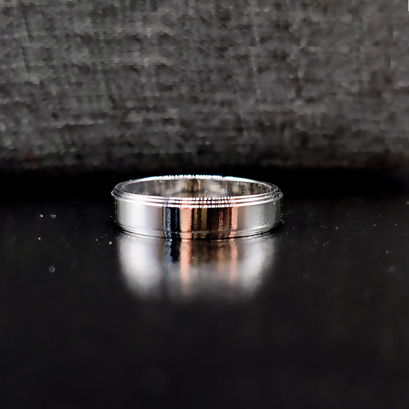 Minimalist Tier Layered Engravable Plain White Gold Men’s Wedding Ring lay on table