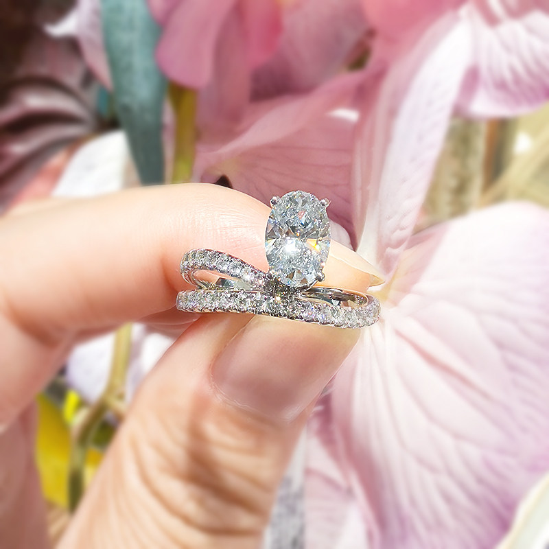 Brilliant 4 Prong Oval Cut Man Made Diamond Ring With Split Half Pave Winding Shank in hand