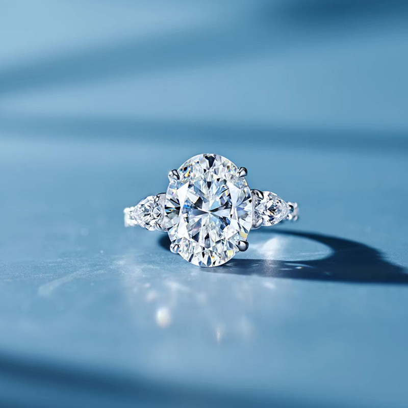 Oval Cut Main Stone with 2 Pear Cut Side Stone Lab Diamond Engagement Ring blue background