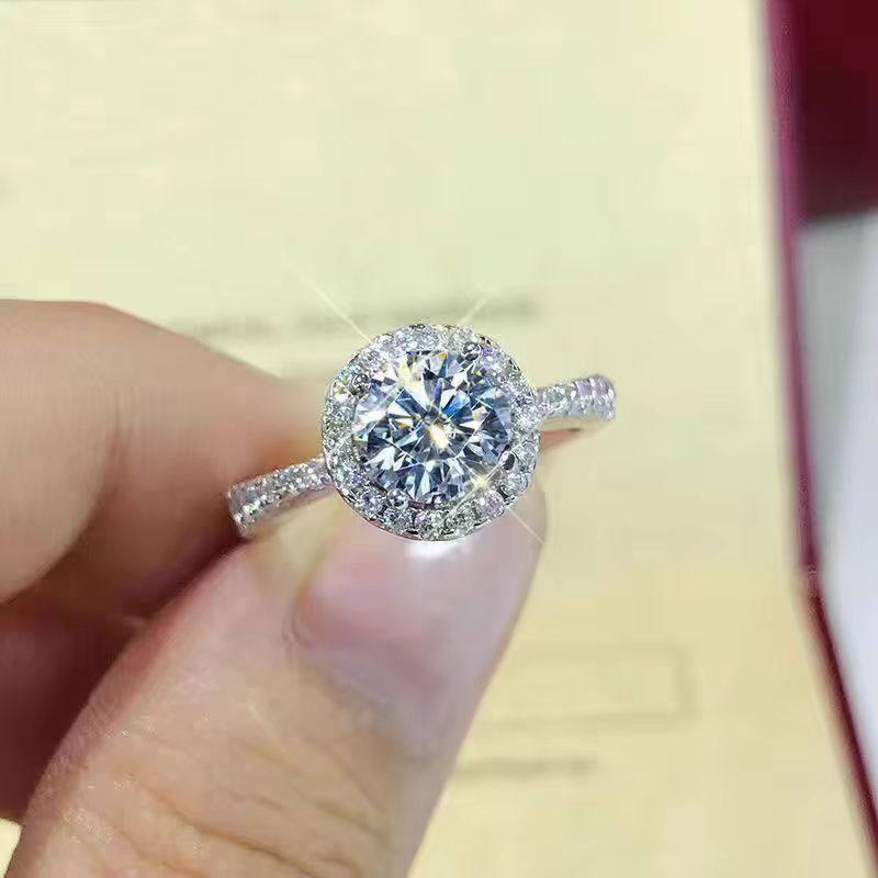 4 Prong Round Cut Halo Bud-Shaped Head Diamond Ring With Half Eternity Pave Shank in hand